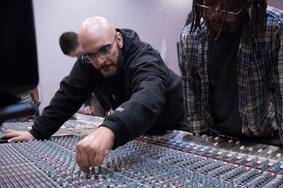 Image of audio engineer Mike Peña working on an SSL board.